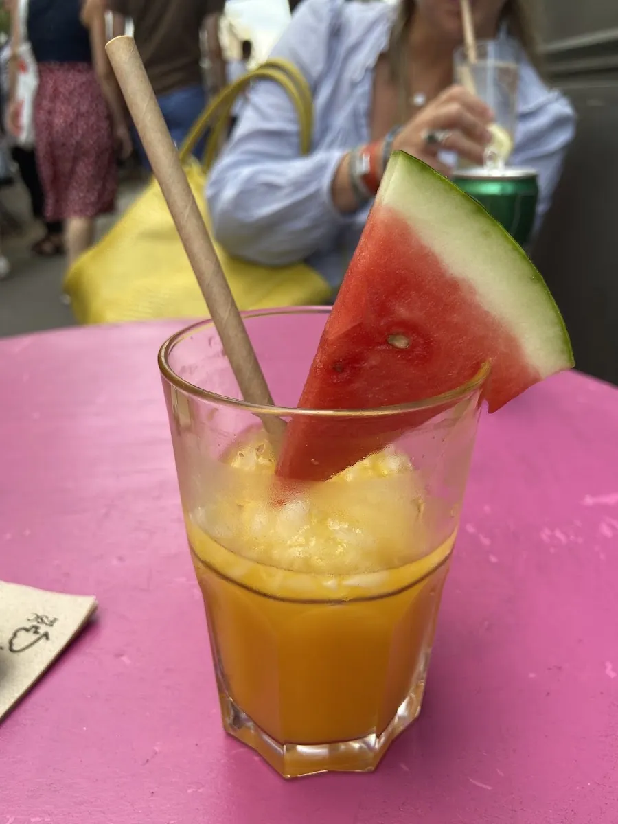 Jus d'orange pressé et pastèque sur une table rose